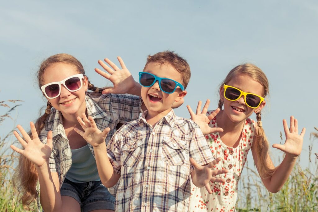 Three children laughing in the summer sun