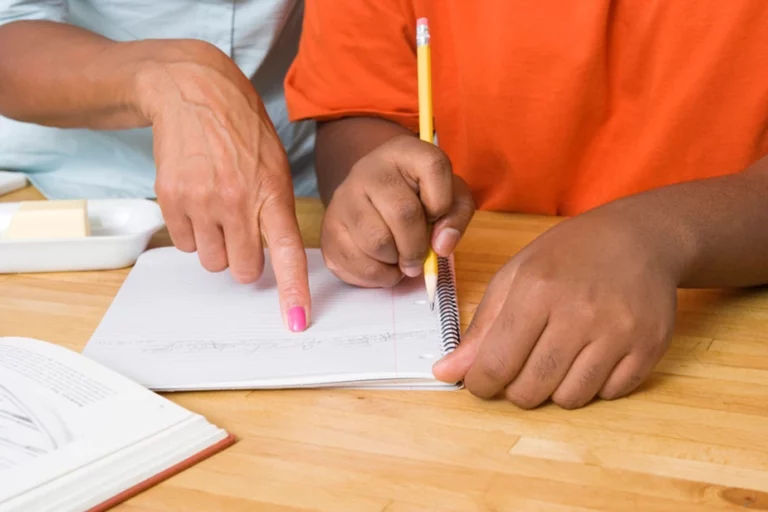 Teacher pointing at words on student's notebook